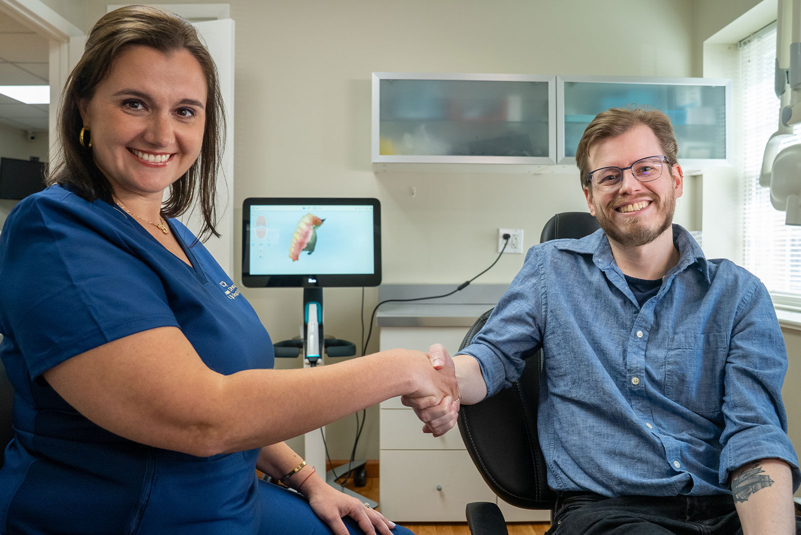 doctor and patient shaking hands and smiling after aligner procedure