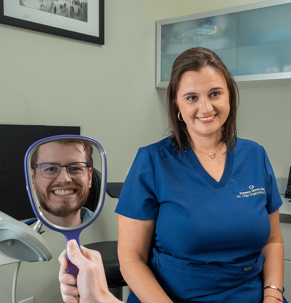 patient smoking brightly at mirror after their dental procedure