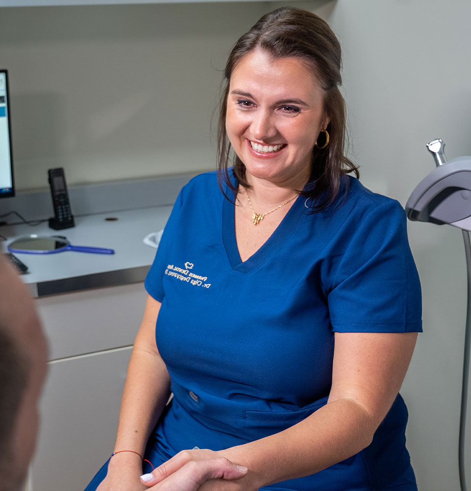 doctor smiling brightly while shaking hands with full mouth implant patient