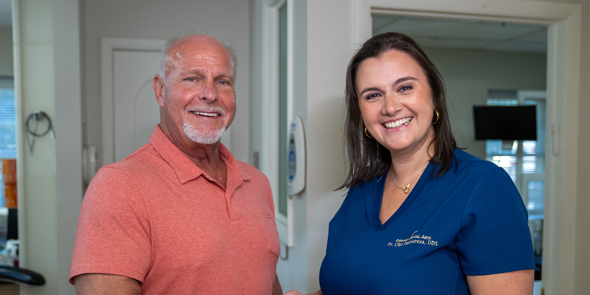patient and doctor smiling brightly together after patient dental procedure
