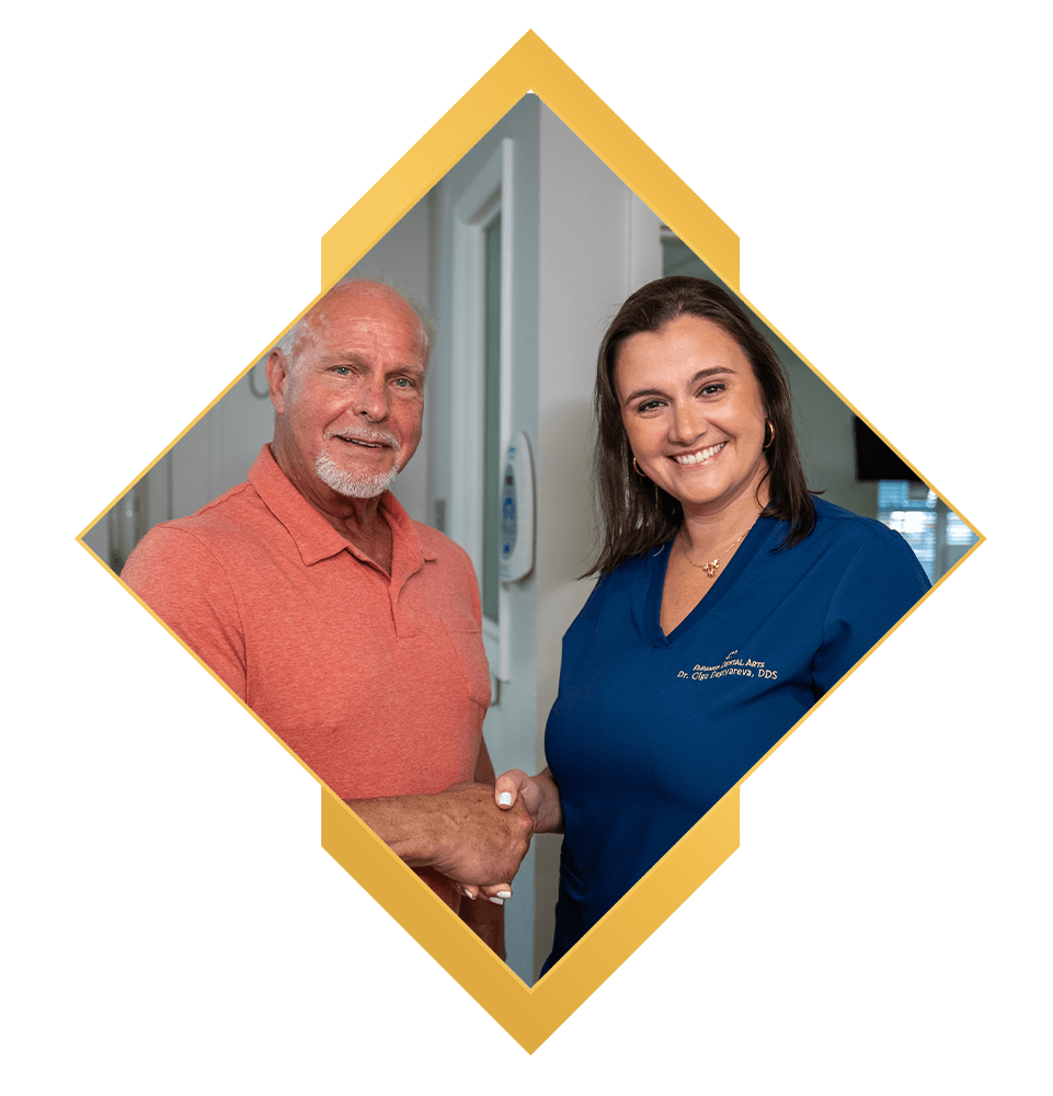 doctor and patient shakings hands and smiling brightly after dental procedure