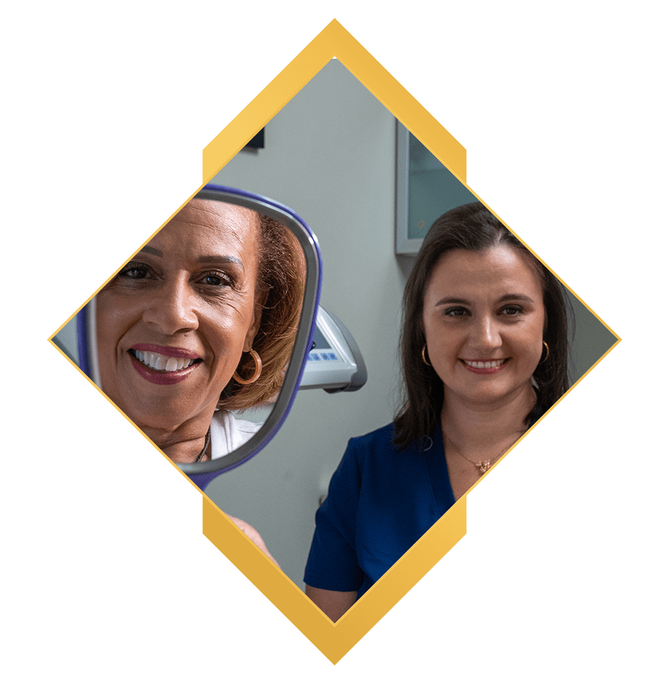 dental patient smiling brightly with doctor after patient's implant procedure