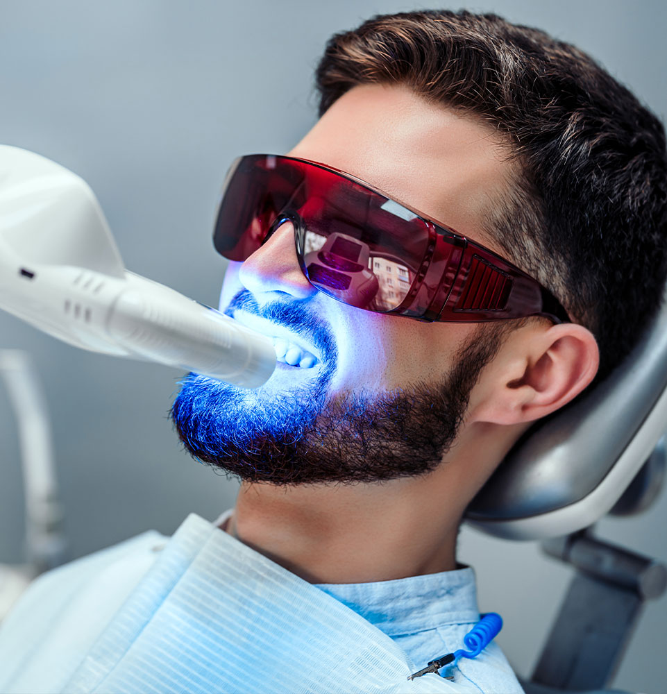 Close up view of man undergoing laser tooth whitening treatment