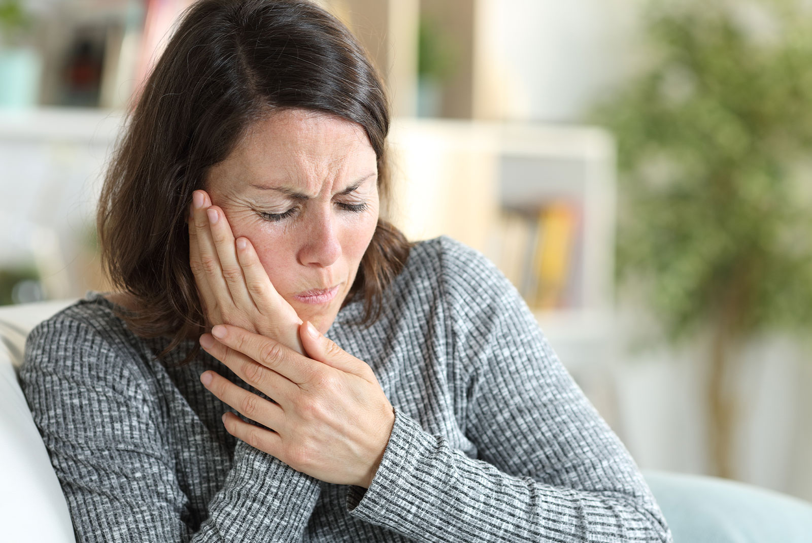 female having mouth pain within the comfort of their own home